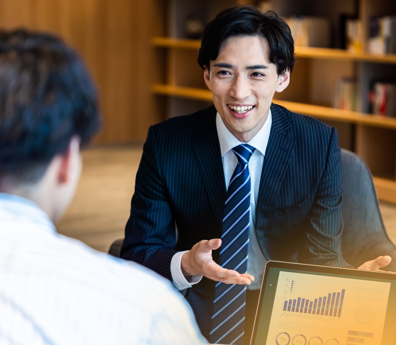企業の方へ画面を見せながら説明する社員